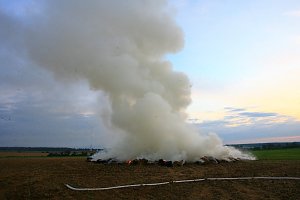 Brennende Strohballen zwischen Holz- und Kirchengel