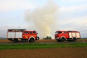 Brennende Strohballen zwischen Holz- und Kirchengel