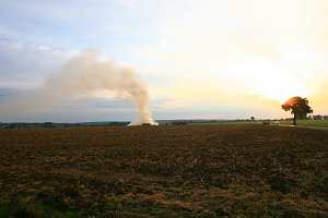 Brennende Strohballen zwischen Holz- und Kirchengel