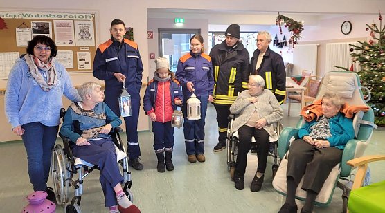 Junge Feuerwehrleute bringen das Friedenslicht ins Seniorenheim (Foto: K.Krausholz)