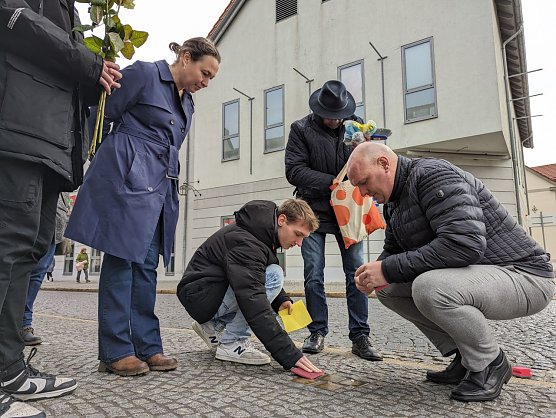 Sch&uuml;lerinnen und Sch&uuml;ler des Geschwister-Scholl-Gymnasiums k&uuml;mmerten sich in der Hauptstra&szlig;e gemeinsam mit ihrem Lehrer Martin Brauer (2.v.re.), Dr. Carolin Sch&auml;fer, Leiterin des Schlossmuseums (3.v.re hinten), Claudia Langhammer, Leiterin der Stabsstelle Kultur/Wirtschaftsf&ouml;rderung/Tourismus (4.v.re. hinten) und Sondersh&auml;user B&uuml;rgern um das S&auml;ubern der Stolpersteine.  (Foto: Stadt Sondershausen)