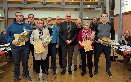 Marcus Reichhardt (links), Michaela Aquillon (3.v.li.), Karin Hafermalz (3.v.re.) und Ronny Kuhmann (rechts) nahmen ihre Auszeichnungen als Gewinner des B&uuml;rgerbudgets 2025 von B&uuml;rgermeister Steffen Grimm (5.v.re.) und den Fraktionsvorsitzenden Lars Boltze, CDU (2.v.li), Dagmar Sonneck, SPD (4.v.li.). Holm Suffa, AfD (hinten Mitte), Tobias Schneegans, VS (4.v.re.) und Jens Koschinek, Die Linke (2.v.re.) entgegen. (Foto: Janine Skara)