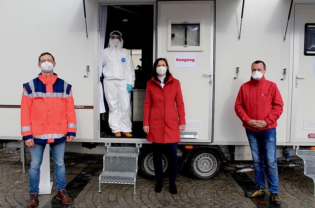 Bild: v.l. Sandro Bauer (DRK), Sandra B&ouml;hme (Rettungsassistentin in Schutzkleidung), Landr&auml;tin Antje Hochwind-Schneider, Sven &Ouml;sterheld (DRK)