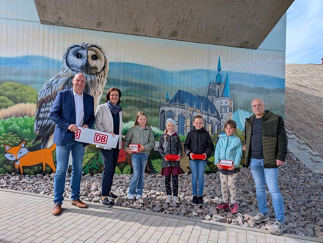 Bild: Iva, Eva, Maila und Zoey von der Grundschule Hohenbra pr&auml;sentierten B&uuml;rgermeister Steffen Grimm (links), Landr&auml;tin Antje Hochwind-Schneider (2.v.li.) und Deutsche Bahn-Projektleiter Marco Kresse (rechts) stolz ihre selbst entworfenen Bilder am Br&uuml;ckenpfeiler