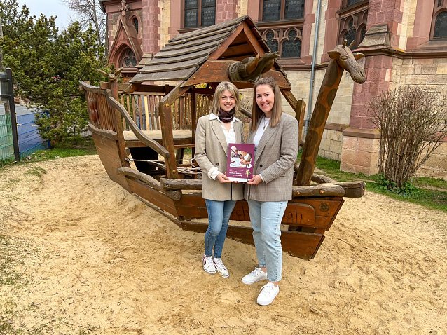 Bild: Zwei Frauen vor einem Holzspielschiff