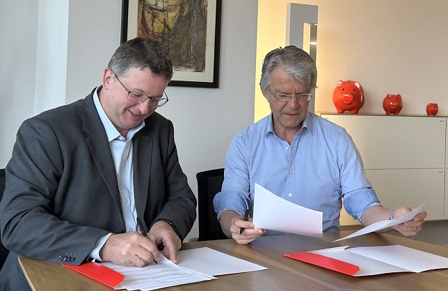 Bild: Seeber und Klajner unterzeichnen den Vertrag