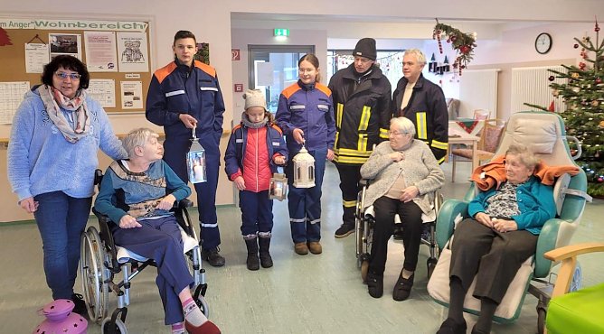 Junge Feuerwehrleute bringen das Friedenslicht ins Seniorenheim (Foto: K.Krausholz)