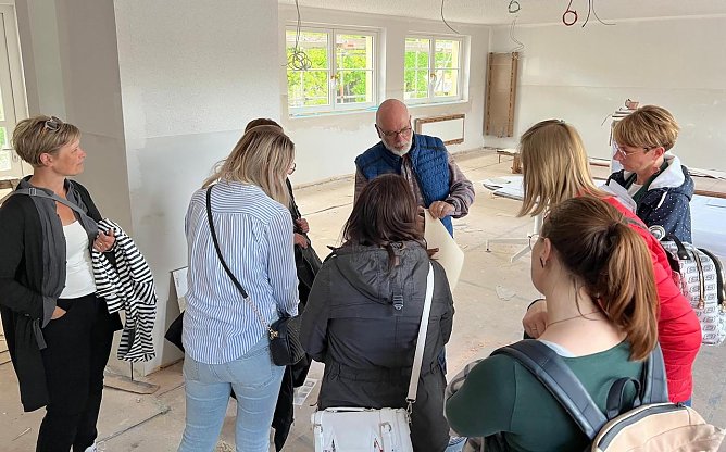 Thomas K&uuml;hn (Mitte), Fachgebietsleiter Hochbau/Geb&auml;ude- u. Energiemanagement der Stadtverwaltung, zeigt den Elternvertretern die Pl&auml;ne f&uuml;r die Innenraumgestaltung der Kita K&auml;the Kollwitz. (Foto: Janine Skara)