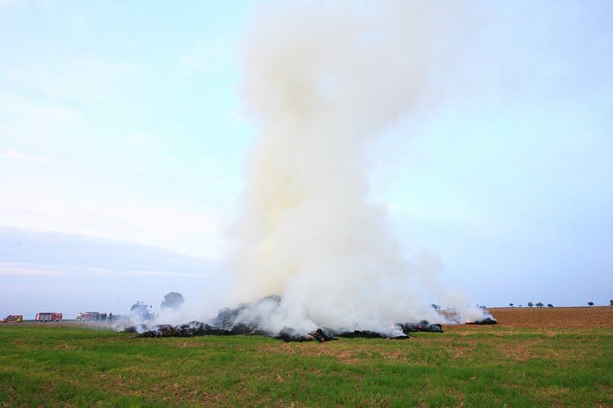 Brennende Strohballen zwischen Holz- und Kirchengel